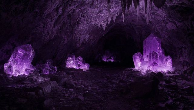 Glowing purple crystal cavern casting ethereal violet light with giant amethyst clusters