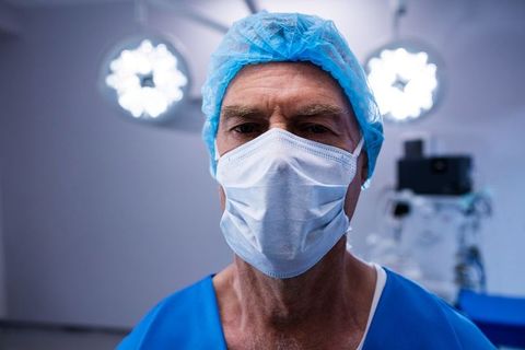Senior surgeon with mask in operating room