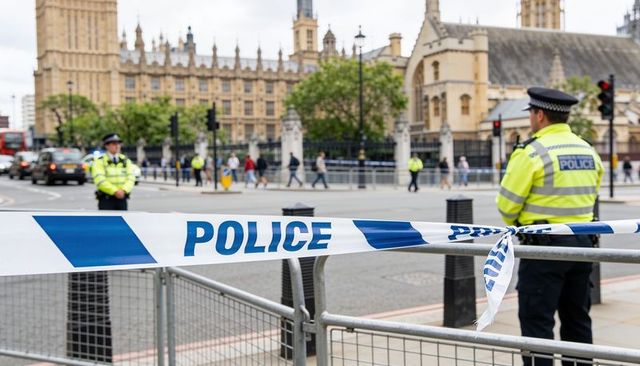 Police cordon outside houses of parliament with officers in high-visibility jackets