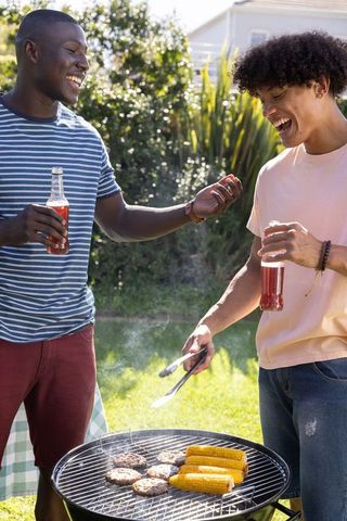 Diverse Male Friends Enjoying Backyard BBQ Grilling