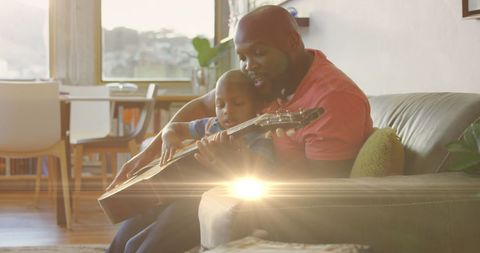 Father Bonding with Son Playing Guitar Sunlit Room - Download Free Stock Images Pikwizard.com