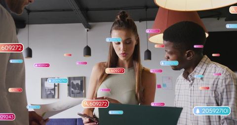 Young businesswoman reviewing laptop and phone with team amid digital analytics tags
