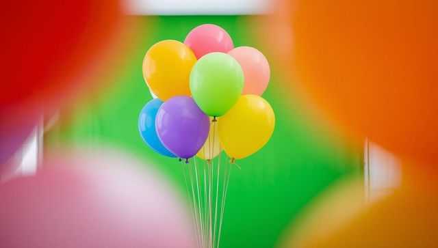 Vibrant colorful balloons against green wall celebrating decor