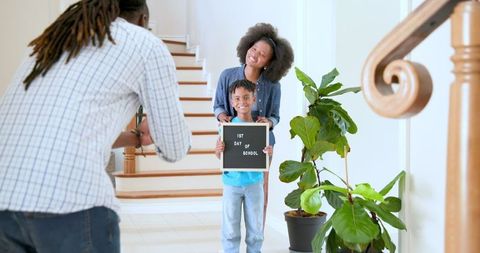 Family celebrating child's first school day with joyful photo