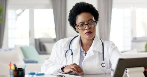 Female Doctor Using Tablet for Virtual Consultation in Office