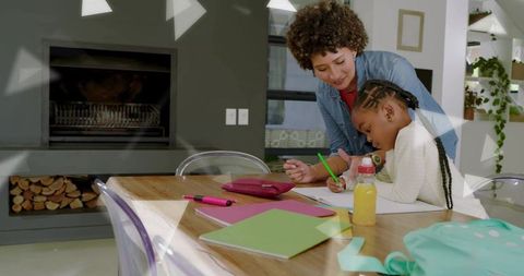 Adult woman guiding child doing homework at table, cozy home learning moment