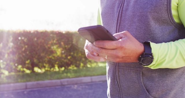 Close-Up of Man Checking Smartphone Outdoors in Daylight - Download Free Stock Images Pikwizard.com