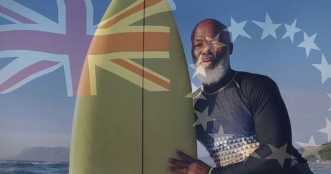 Elderly surfer with surfboard on sunny beach holding inspiring initiative banner