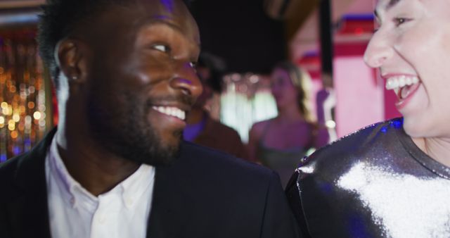 Two friends enjoying themselves and laughing at a night party. This vibrant image portrays the joy and camaraderie of socializing and celebrations, making it perfect for advertisements, event promotions, and social media content related to happiness, friendship, and nightlife.