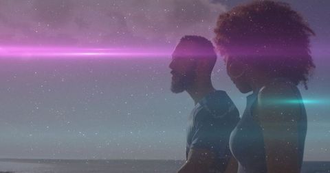 Romantic Couple Strolling Beach at Dusk with Ethereal Light Effects