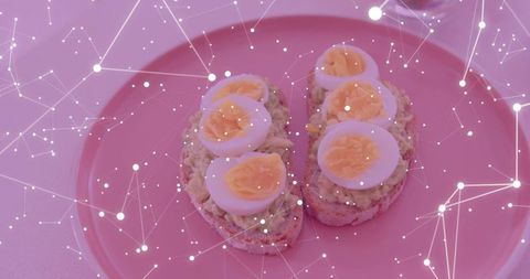Avocado egg toasts on pink plate with digital network overlay