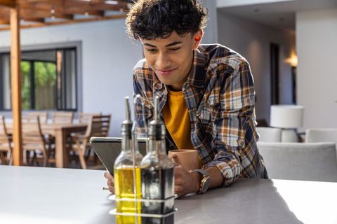 Young Man Using Tablet in Modern Kitchen with Cozy Ambiance
