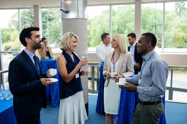 Business executives interacting with each other while having coffee at conference center