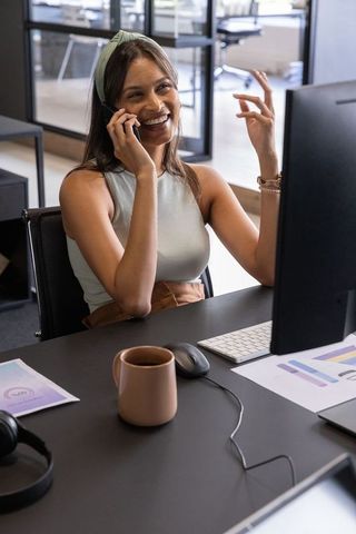 Businesswoman communicating via smartphone in modern office setup