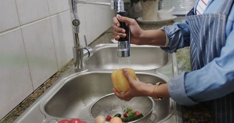 Sustainable Living: Washing Vegetables in Modern Kitchen