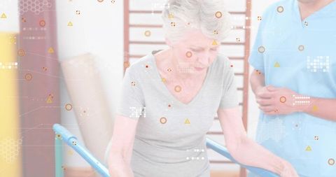 Senior woman walking using parallel bars for gait training with therapist in clinic