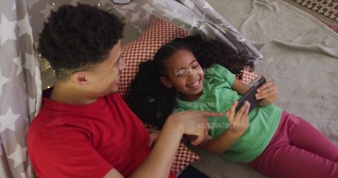 Father and Daughter Enjoying Time on Tablet in Playful Tent