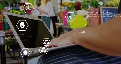 Florist using laptop at market stall with sustainability data overlays for analytics