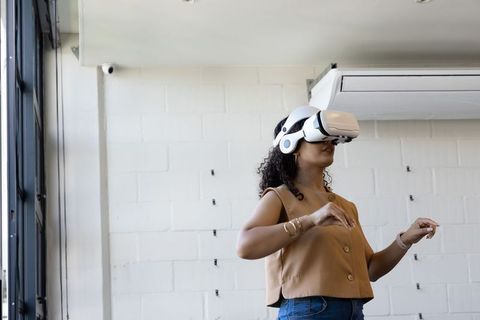 African American Woman Testing VR Headset in Modern Minimalist Studio Workspace
