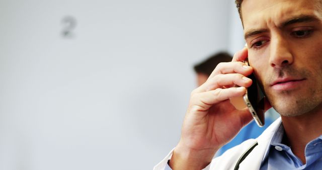 Doctor on Smartphone Having Serious Conversation in Hospital - Download Free Stock Images Pikwizard.com