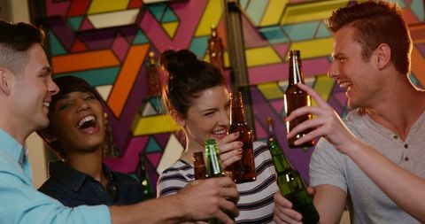 Friends Laughing and Toasting in Vibrant Bar