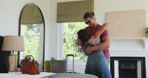 Couple Embracing While Packing Suitcase for Exciting Travel Adventure