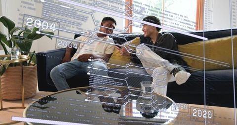 Young men sharing smartphone on sofa with futuristic holographic data overlay