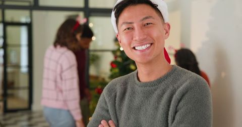 Smiling Coworker in Santa Hat at Festive Office Holiday Gathering