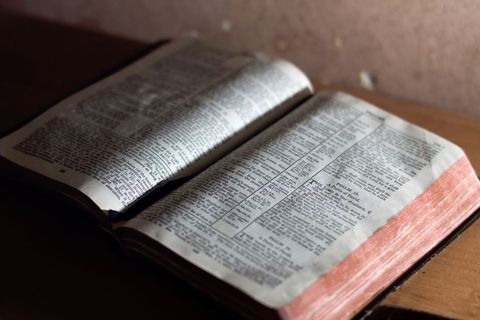 Open bible book on wooden table with soft ambient light