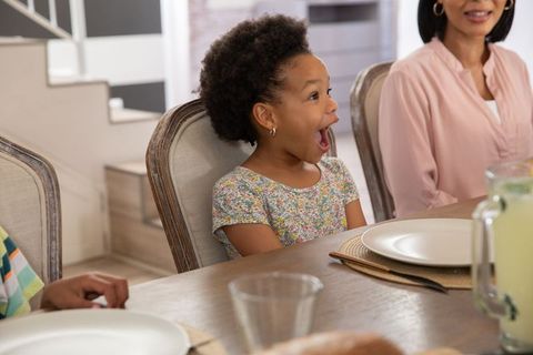 Excited Young Girl During Family Dinner Gathering
