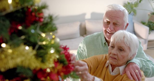 Happy senior caucasian couple decorating christmas tree at home, slow motion - Download Free Stock Photos Pikwizard.com