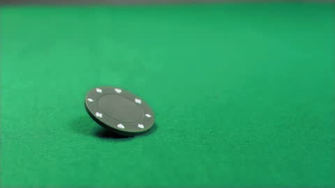 Rotating Poker Chip in Slow Motion on Green Table