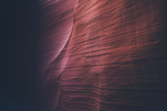 This image captures the textured surface of natural rock formations with rich red tones, often seen in canyons. It is useful for backgrounds in artistic projects, educational materials on geology, or even design inspiration due to its abstract and organic aesthetic.