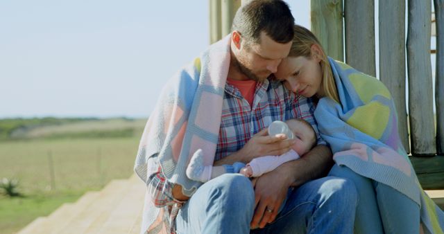 Loving Parents Feeding Baby Outdoors Wrapped in Blanket - Download Free Stock Images Pikwizard.com