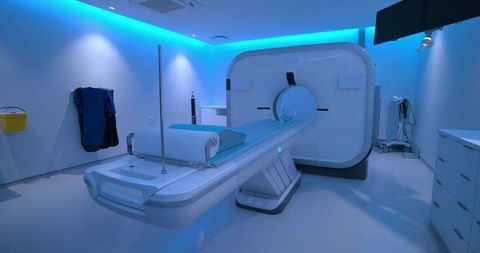 Modern ct scanner in blue-lit hospital imaging suite with motorized patient table