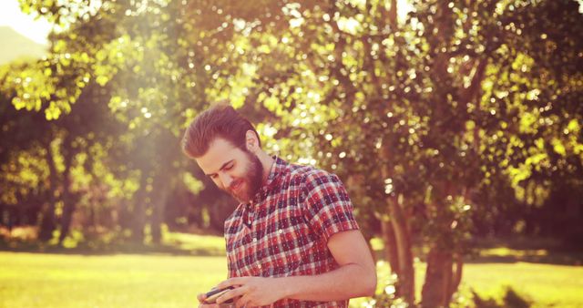 Bearded Man Using Smartphone in Sunlit Park - Download Free Stock Images Pikwizard.com