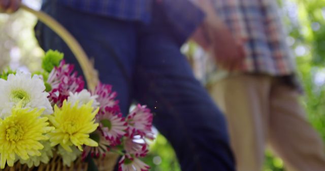 Senior couple walking in garden with flower basket