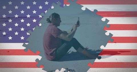 American Patriotism: Man Using Smartphone on Beach with Flag Overlay