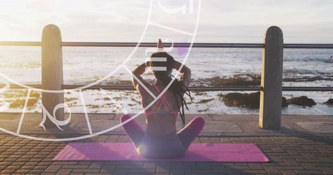 Woman Practicing Yoga at Seaside with Astrological Symbols
