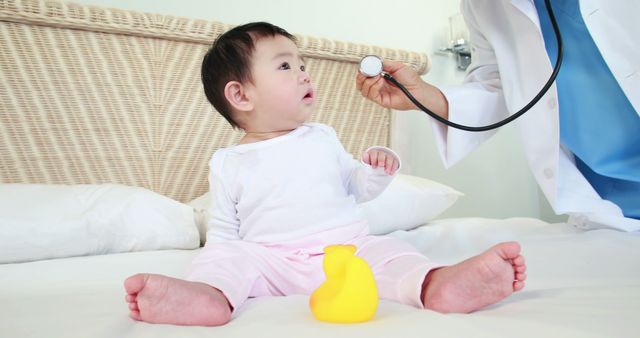 Doctor examining baby with stethoscope on bed - Download Free Stock Images Pikwizard.com