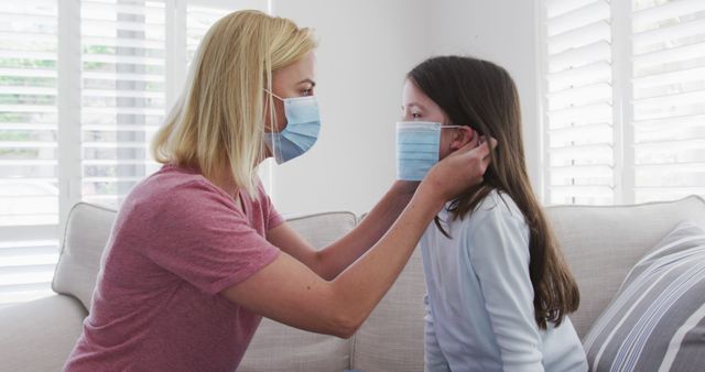 Mother Adjusting Face Mask on Young Daughter at Home - Download Free Stock Images Pikwizard.com