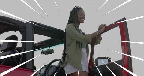 Stylish woman embracing adventure in red convertible suv