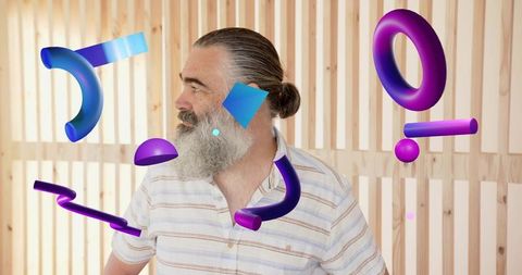 Bearded man with man bun surrounded by floating purple-blue 3d abstract geometric shapes