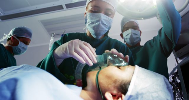 This photo depicts a medical team performing surgery on a patient who is under anesthesia. The surgical staff is focused and equipped with masks and gloves in a sterile operating room. This image can be used in healthcare articles, medical education materials, or hospital promotional content.