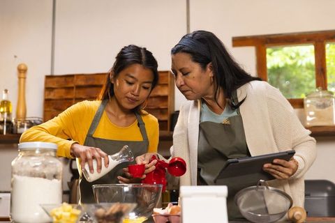 Mother and daughter enjoying home cooking lesson together