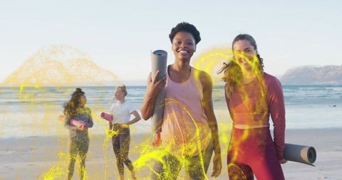 Walking beach yoga group carrying mats with yellow powder splash fitness and wellness