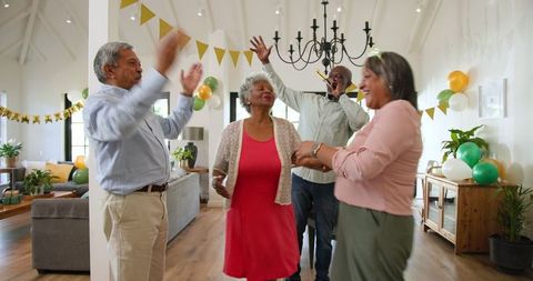 Senior Friends Enjoying Birthday Celebration in Living Room