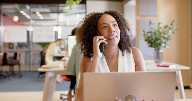 Businesswoman Talking on Phone While Working at Office Desk - Download Free Stock Images Pikwizard.com