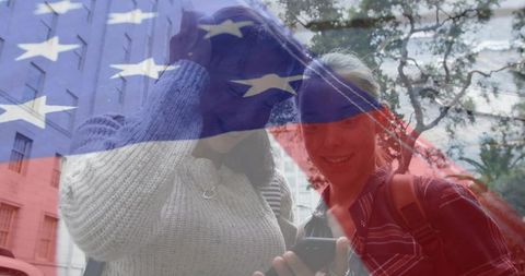Teens sharing smartphone under american flag overlay urban friendship concept