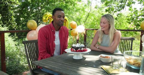 Man and woman celebrating outdoor birthday party